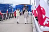 Mennesker går over en gangbru mellom røde og hvite flagg i Fredrikstad.