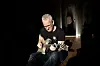 Eystein Garberg sitter på gulvet med en elektrisk gitar.