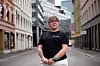 Person i svart T-skjorte står på en gate mellom bygårder under NAFs landsmøte 2023.