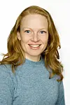 Portrett av Elin Halvorsen med langt lyst hår og blå genser mot hvit bakgrunn.