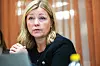 Kjersti Stenseng sitter ved et bord i et trepanelkledd rom.
