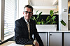 Hans Ole Rian sitter i et lyst kontor omgitt av grønne planter.