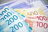 Nærbilde av fargerike norske sedler på et bord, blant annet 200-, 100- og 500-kroner.
