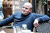 Stian Tveitan sitter ved et bord på en kafé iført mørk blå genser.