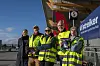 Fem streikende SAS Link-ansatte i refleksvester foran en flyplass, med et skilt der det står «Vi streiker».